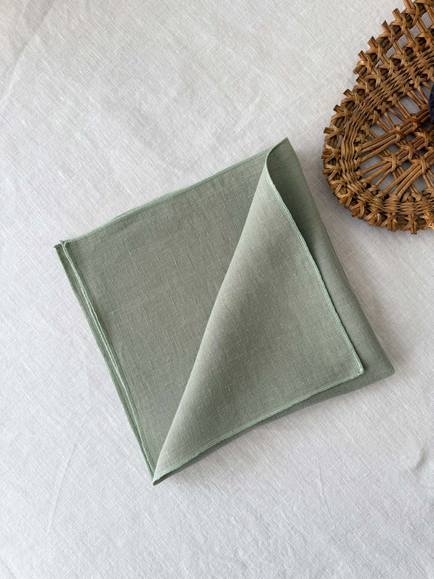 Serviette de table en lin vert sauge avec ourlet roulé