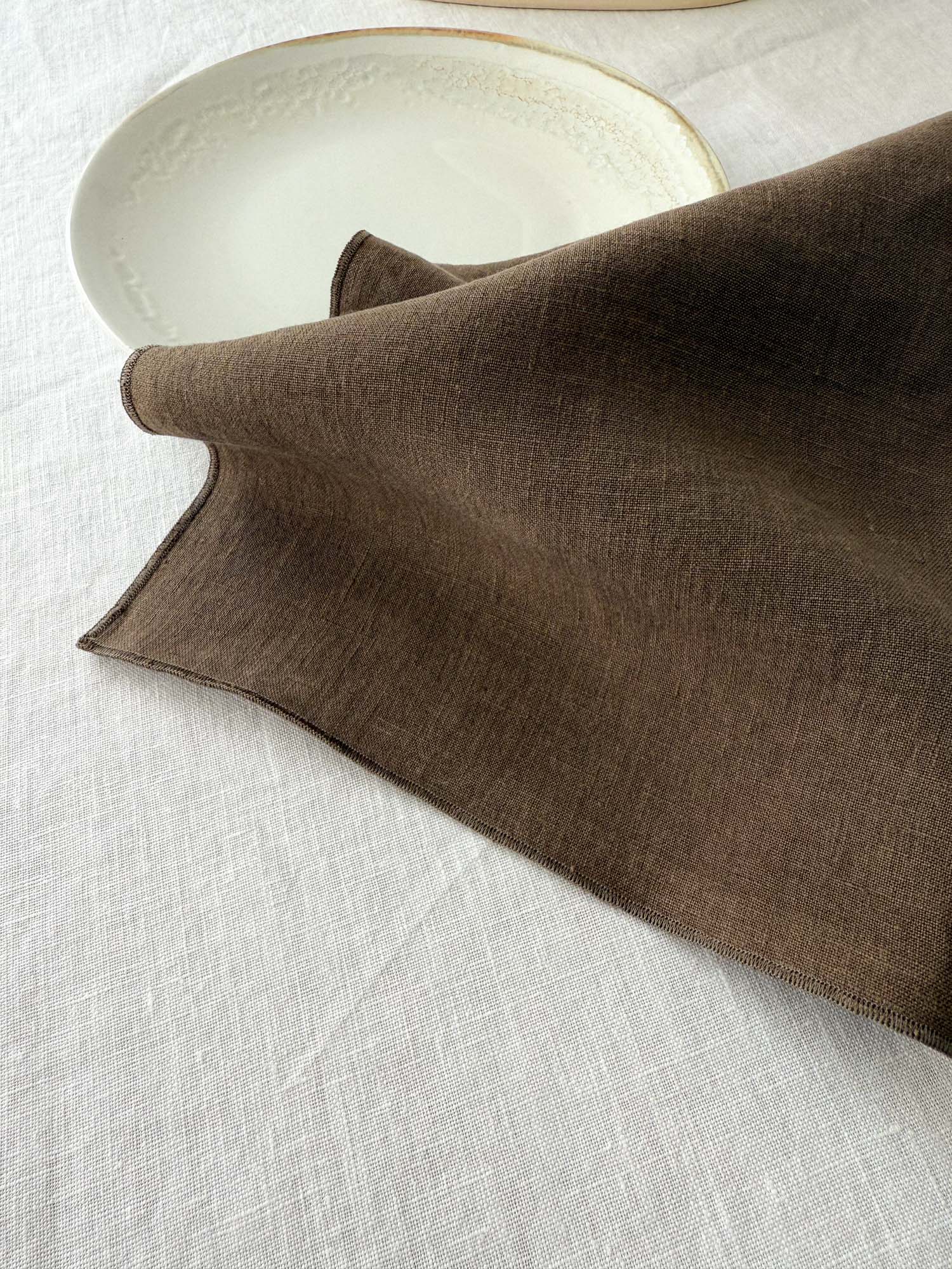 Serviette de table en lin marron avec ourlet roulé