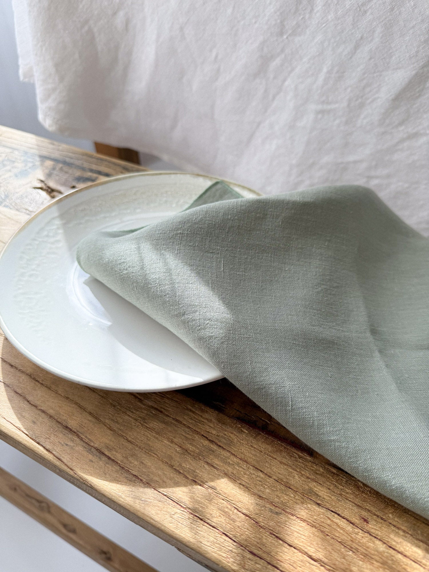 Serviette de table en lin vert sauge avec ourlet roulé